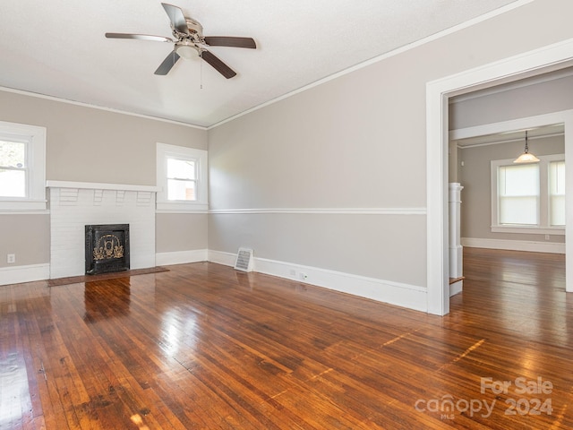 1411 Lineberger Ave, Gastonia, NC 28052 - unfurnished living room featuring wood-type flooring, ceiling fan, crown molding, a brick fireplace, and baseboards