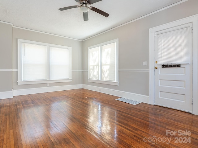 empty room featuring ceiling fan, hardwood / wood-style floors, crown molding, and a textured ceiling