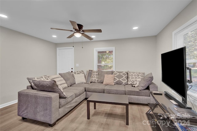 living room with light wood-type flooring and ceiling fan