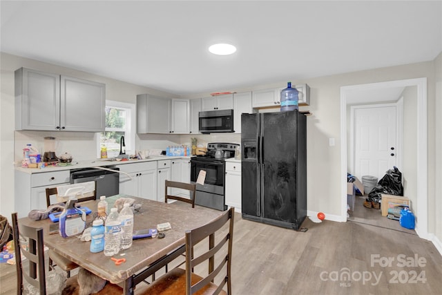 kitchen featuring backsplash, stainless steel appliances, light hardwood / wood-style floors, and sink