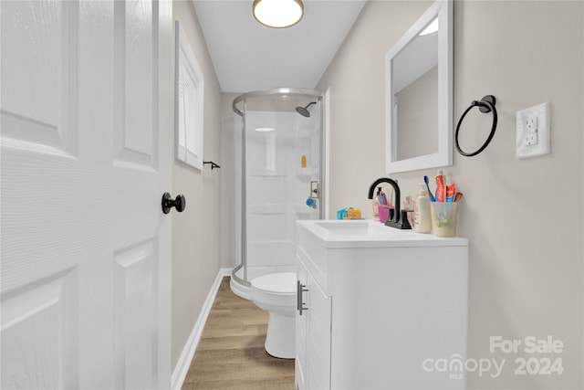 bathroom with hardwood / wood-style flooring, toilet, an enclosed shower, and vanity