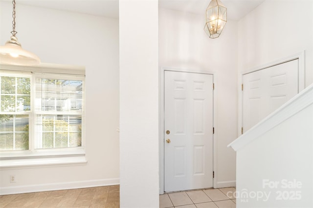 tiled foyer with an inviting chandelier