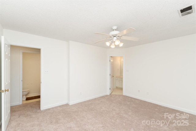 empty room featuring light carpet, ceiling fan, and a textured ceiling