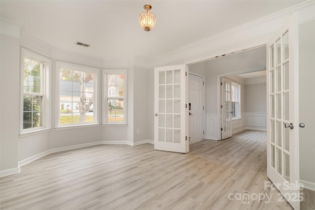 unfurnished room with crown molding, light hardwood / wood-style flooring, and french doors