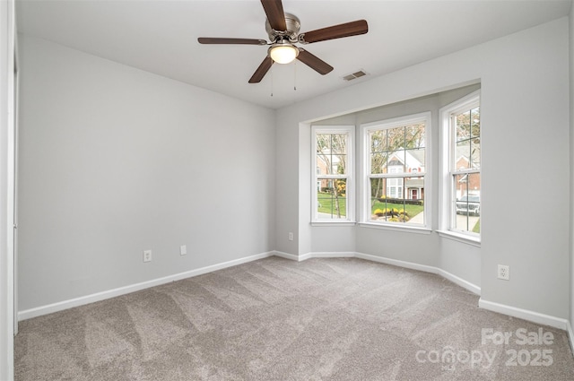 empty room featuring ceiling fan and light colored carpet