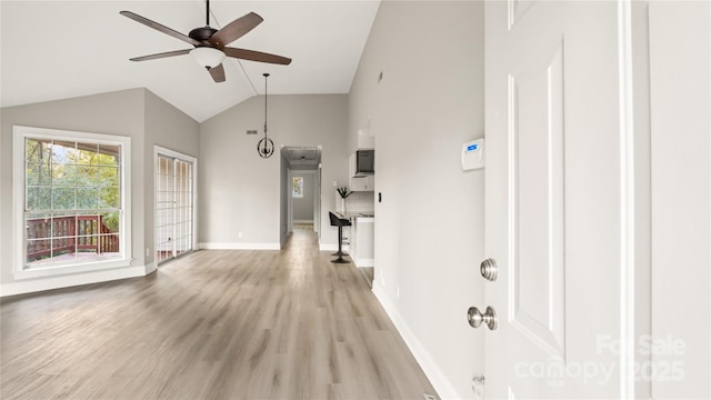 entryway with ceiling fan, lofted ceiling, and light wood-type flooring