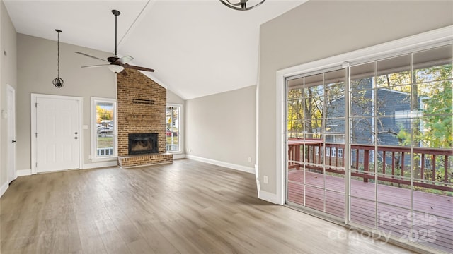 unfurnished living room featuring ceiling fan, a healthy amount of sunlight, hardwood / wood-style floors, and a fireplace