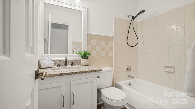 full bathroom featuring vanity, tiled shower / bath, tile walls, and toilet