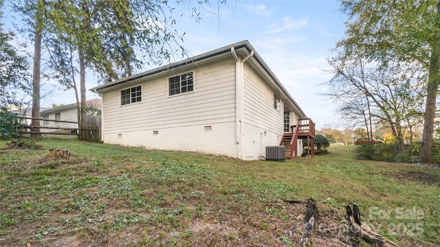 view of side of property with a yard, a deck, and central air condition unit