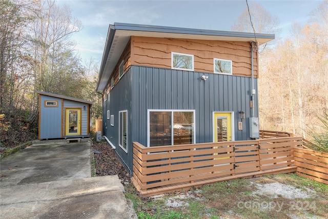 rear view of house featuring a storage unit