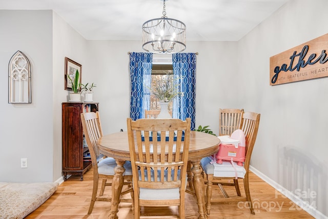 dining space featuring light wood-type flooring and a chandelier