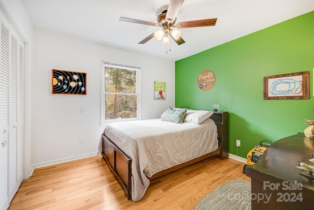 bedroom with a closet, light hardwood / wood-style floors, and ceiling fan