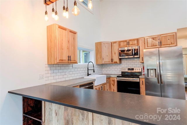 kitchen with sink, appliances with stainless steel finishes, tasteful backsplash, light brown cabinets, and hanging light fixtures