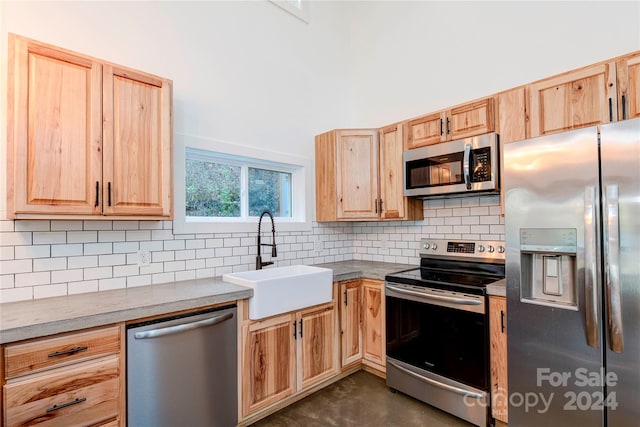 kitchen featuring stainless steel appliances, sink, decorative backsplash, and light brown cabinets