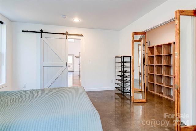 unfurnished bedroom with multiple windows and a barn door