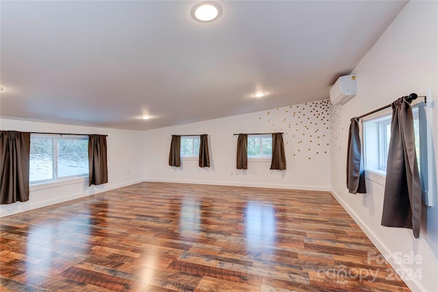 unfurnished living room with an AC wall unit, lofted ceiling, and dark hardwood / wood-style floors