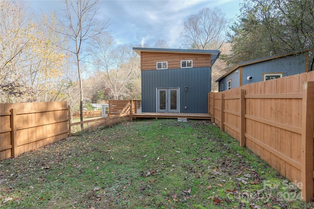 rear view of property with french doors and a yard