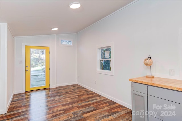 entrance foyer featuring dark hardwood / wood-style flooring, lofted ceiling, and crown molding