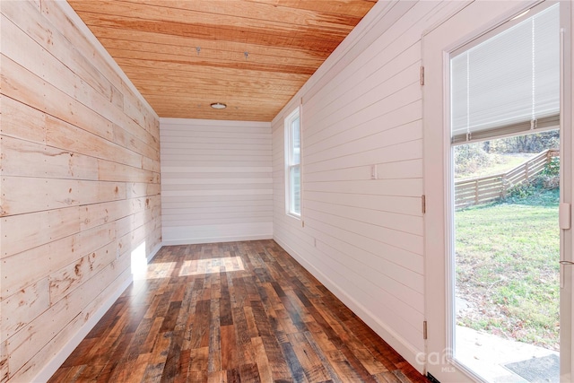 spare room with wooden walls, wood ceiling, and dark hardwood / wood-style flooring