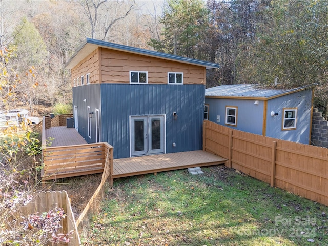 rear view of house with french doors, a yard, and a deck