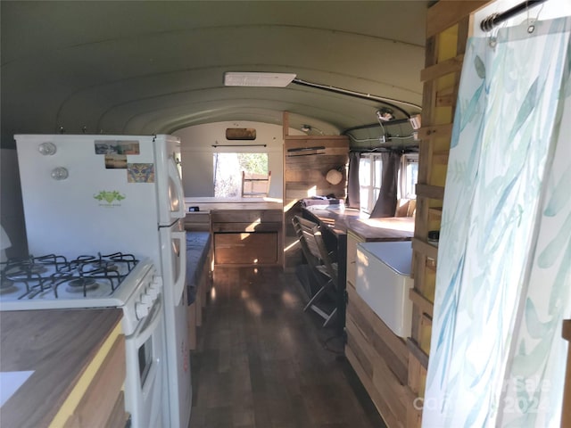 kitchen featuring dark wood-type flooring, lofted ceiling, and white gas range oven