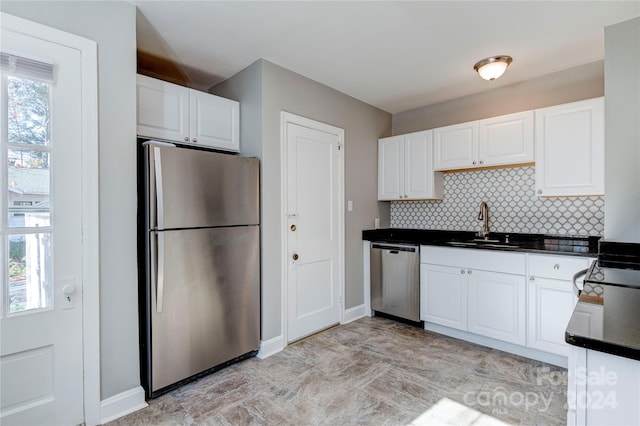 kitchen with stainless steel appliances, white cabinets, sink, and tasteful backsplash