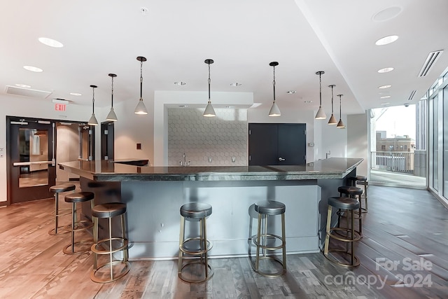 kitchen featuring a kitchen bar and pendant lighting