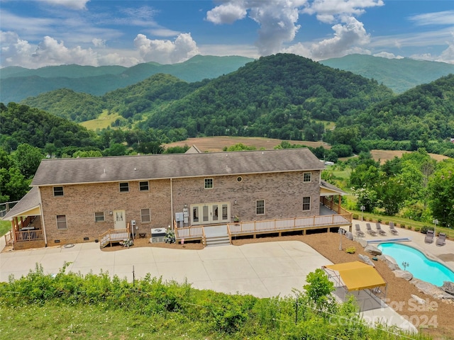 exterior space featuring a swimming pool side deck with mountain view and a patio area