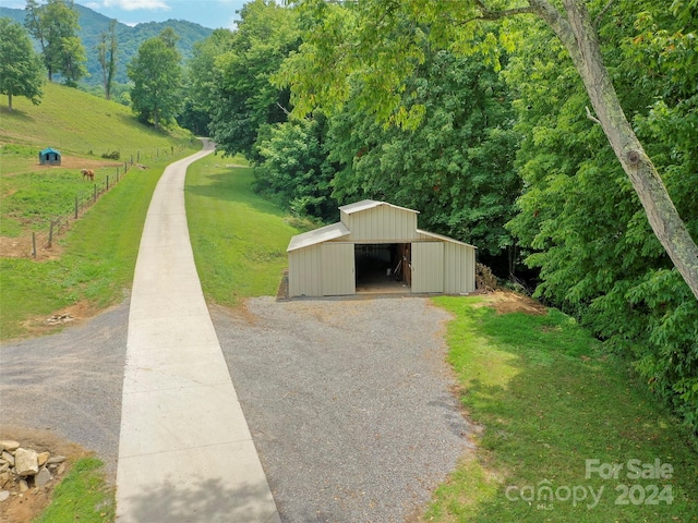 exterior space with a yard, a mountain view, and an outdoor structure