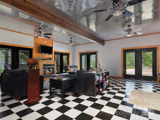 living room featuring a wealth of natural light, french doors, ceiling fan, and beam ceiling