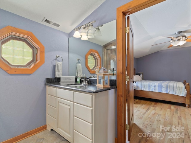 bathroom featuring hardwood / wood-style floors, ceiling fan, vanity, and lofted ceiling