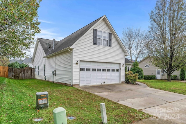 view of side of property featuring a garage and a lawn