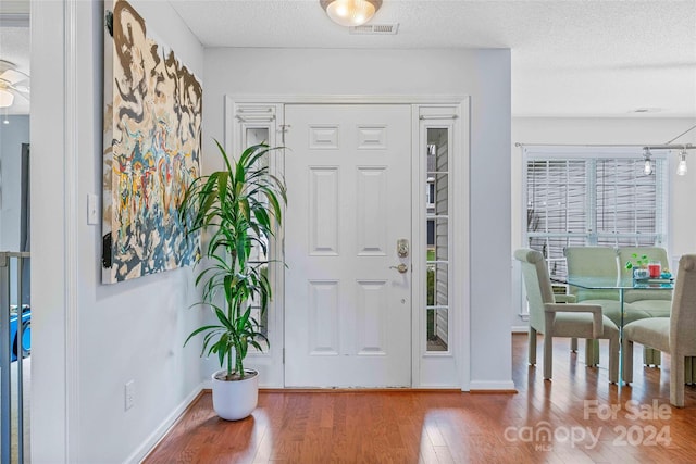 entryway with wood-type flooring, a textured ceiling, and ceiling fan