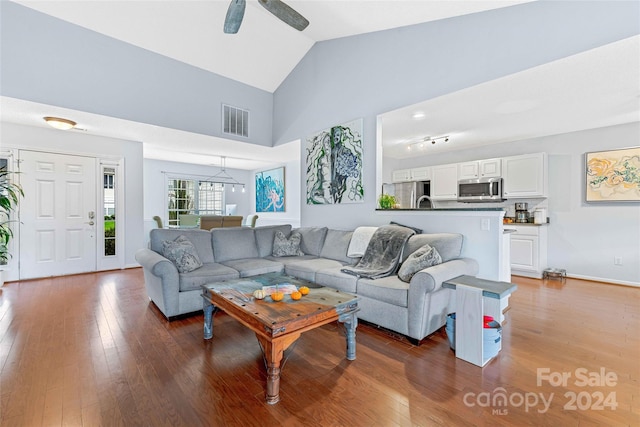 living room with dark hardwood / wood-style floors, high vaulted ceiling, and ceiling fan