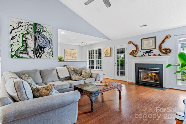 living room featuring hardwood / wood-style floors, high vaulted ceiling, ceiling fan, and a healthy amount of sunlight