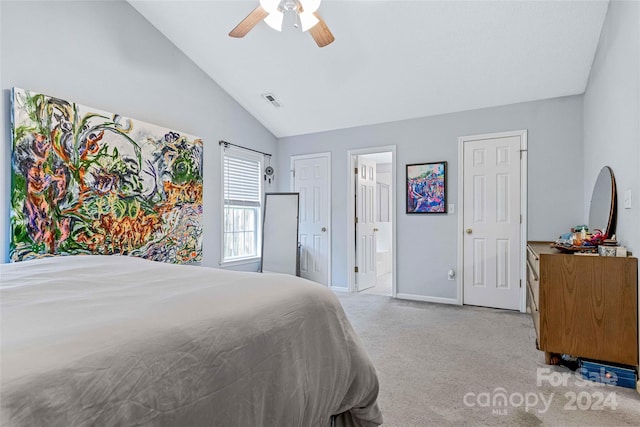 bedroom with light colored carpet, vaulted ceiling, ceiling fan, and ensuite bathroom