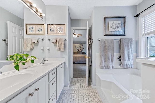 bathroom with a tub, ceiling fan, tile patterned floors, a textured ceiling, and vanity