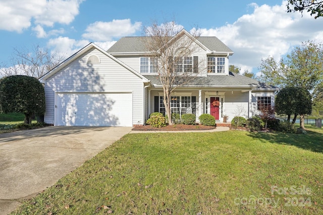 view of property with a garage and a front lawn