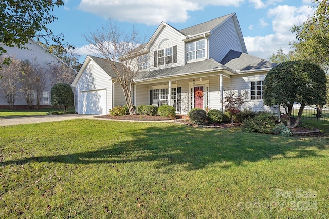 view of front of home with covered porch, a garage, and a front lawn