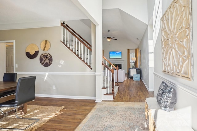 entrance foyer with hardwood / wood-style floors, ceiling fan, crown molding, and high vaulted ceiling