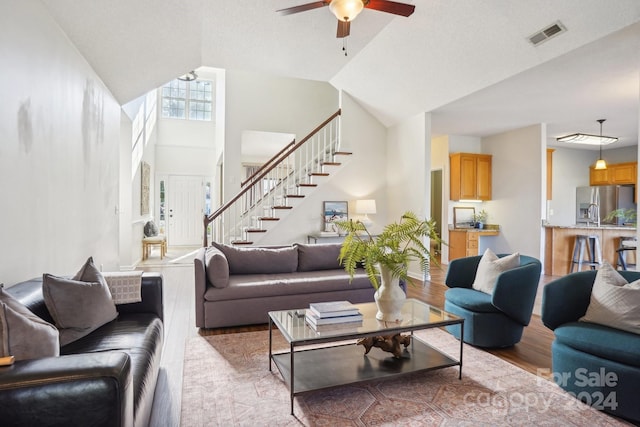 living room with light wood-type flooring, lofted ceiling, and ceiling fan