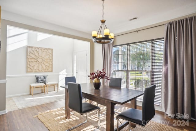 dining area featuring hardwood / wood-style flooring and an inviting chandelier