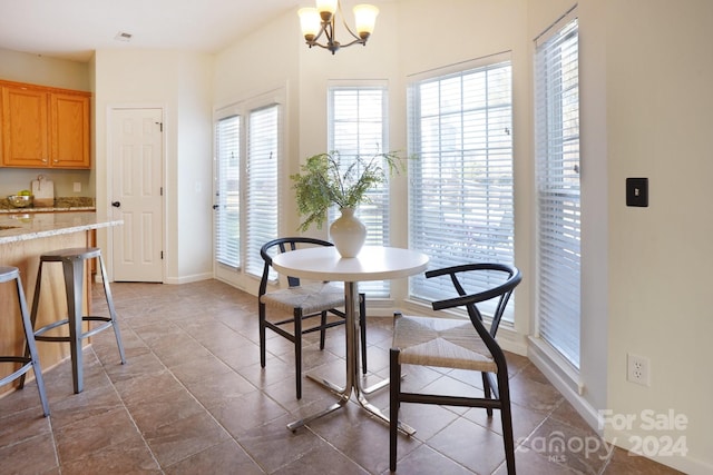 dining room featuring a chandelier, plenty of natural light, and tile patterned floors