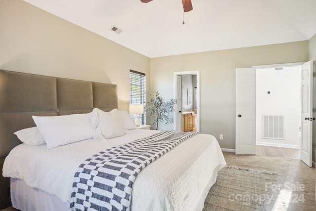 carpeted bedroom with vaulted ceiling, ceiling fan, and ensuite bathroom