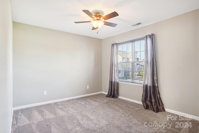 empty room with ceiling fan and light carpet