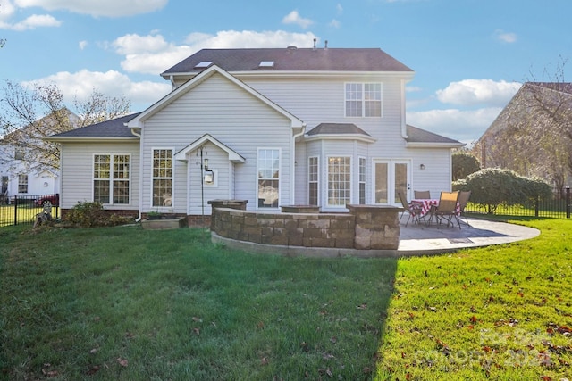 rear view of property with french doors, a lawn, and a patio area