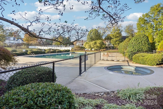 view of swimming pool featuring an in ground hot tub