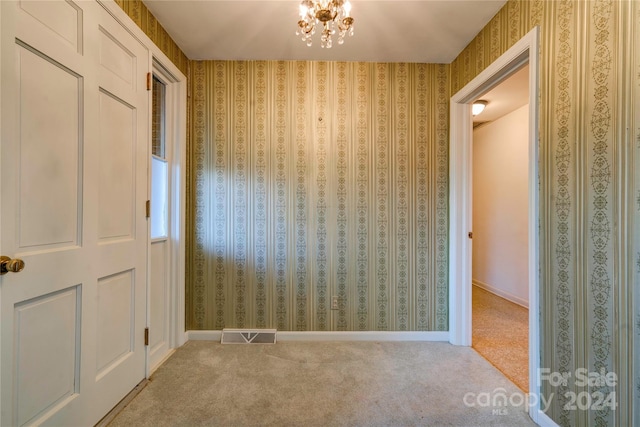 interior space featuring carpet flooring and an inviting chandelier