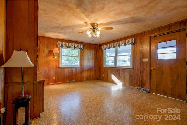 entryway with wooden walls and a wealth of natural light