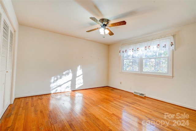 unfurnished bedroom with ceiling fan, a closet, and light wood-type flooring